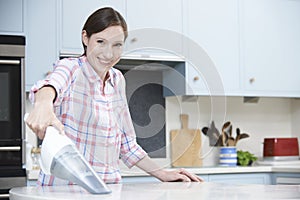 Woman Cleaning Kitchen Using Hand Held Vacuum Cleaner