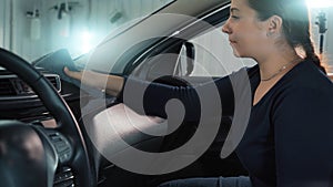 Woman cleaning microfiber flyer plastic panel of car inside, dry cleaning and disinfection of car