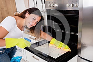 Woman Cleaning The Oven In Kitchen