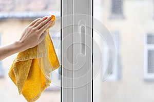 Woman cleaning plastic window in her house