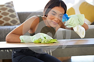 Woman, cleaning service and spraying living room table for bacteria, dust and dirt for health, wellness and safety in