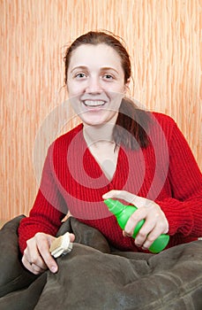 Woman cleaning a sheepskin with whisk broom