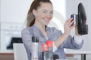 woman cleaning shoes with brush