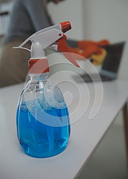 Woman cleaning table using rag and diffuser at home