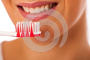 Woman cleaning teeth with toothbrush for perfect hygiene and healthy teeth.