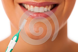 Woman cleaning teeth with toothbrush for perfect hygiene and healthy teeth.