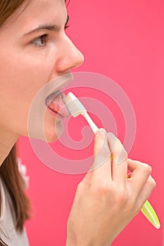 Woman Cleaning Tongue Using Toothbrush