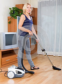 Woman cleaning with vacuum cleaner