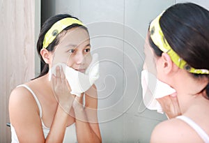 Woman cleaning washing her face with towel reflect with bathroom mirror