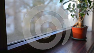 Woman cleaning water condensation on window