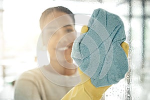 Woman cleaning window, with a cloth in rubber gloves and washing the shower cabin. Glass, hygiene and a female maid or