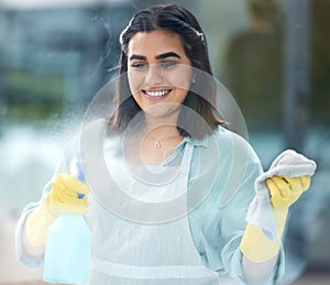 Woman, cleaning or window with spray bottle in home, soap and cloth for hygiene. Female Indian cleaner or worker with