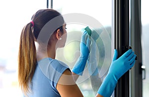 Woman cleaning windows at home