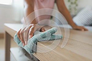 Woman cleaning and wiping the table with microfiber cloth in the living room. Woman doing chores at home.