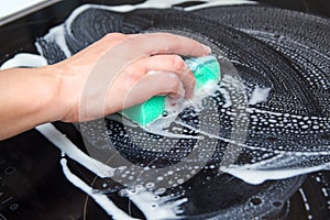 Woman cleans the electronic ceramic hob