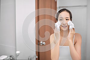 Woman clears a face skin foam on morning