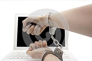 Woman with clenched fists with hands immobilized by handcuffs that hold her wrists together to punish cybercrime in front of a