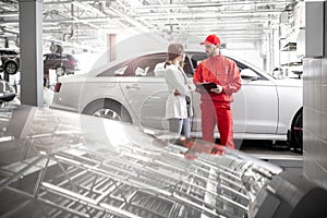 Woman client with auto mechanic at the car service