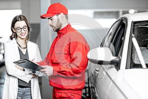 Woman client with auto mechanic at the car service