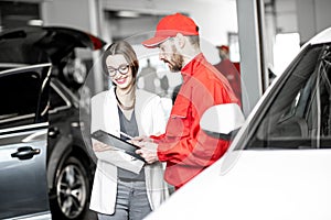 Woman client with auto mechanic at the car service