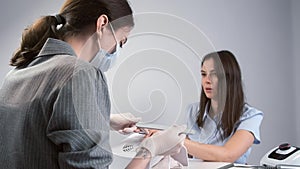 Woman client on manicure is talking with manicurist master in beauty salon.