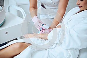Woman client undergoing the hand rejuvenation procedure