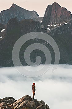 Woman on cliff edge over clouds travel in mountains