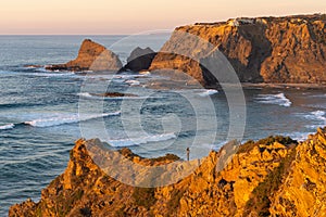 Woman on a cliff at Praia de Odeceixe in Costa Vicentina, Portugal