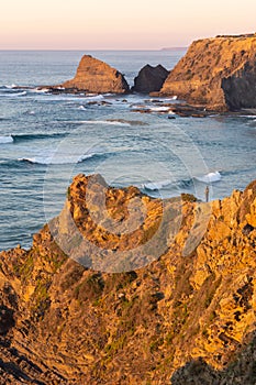 Woman on a cliff at Praia de Odeceixe in Costa Vicentina, Portugal