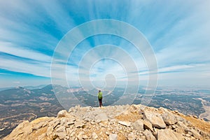 Woman climber with a backpack and a helmet in the mountains. A girl with a backpack walks along a mountain range. adventure and