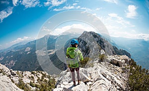 Woman climber with a backpack and a helmet in the mountains. A girl with a backpack walks along a mountain range. adventure and