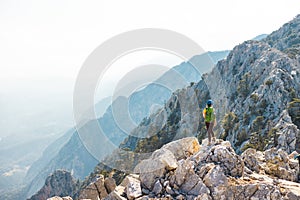 Woman climber with a backpack and a helmet in the mountains. A girl with a backpack walks along a mountain range. adventure and