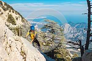 Woman climber with a backpack and a helmet in the mountains. A girl with a backpack walks along a mountain range. adventure and