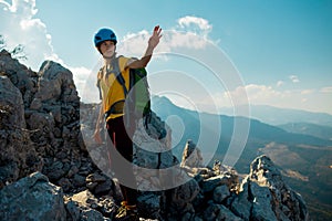 Woman climber with a backpack and a helmet in the mountains. A girl with a backpack walks along a mountain range. adventure and