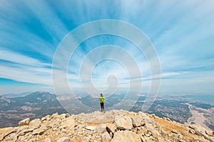 Woman climber with a backpack and a helmet in the mountains. A girl with a backpack walks along a mountain range. adventure and