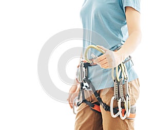 Woman climber in harness holding snap hook carabiner.