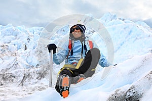 Woman climber resting on top of a glacier