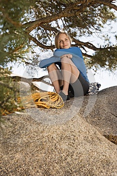 Woman climber sitting on boulder