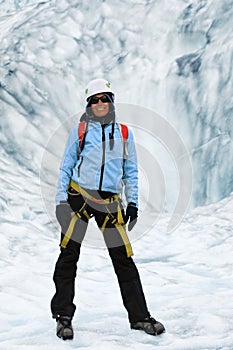 Woman climber stands in the cleft of the glacier