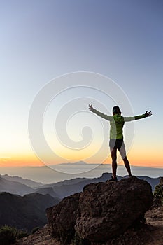 Woman climber success silhouette in inspiring mountains