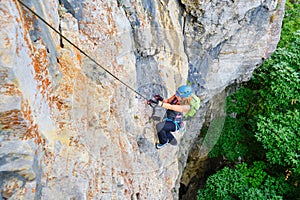 Woman climber on a via ferrata route called Dragons Amphitheater Amfiteatrul Zmeilor in Baia de Fier, Gorj county, Romania