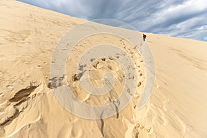 Woman climbing the huge Pyla sand dune