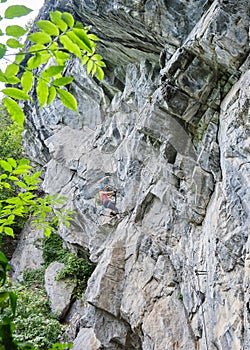 Woman climbing impressive rock formations on difficult via ferrata route called Zimmereben, near Mayrhofen, Zillertal valley