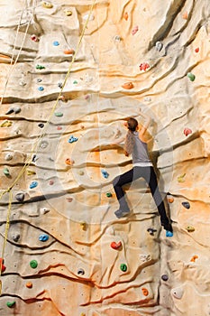 Woman climbing on man-made cliff