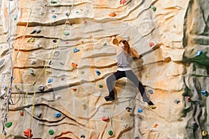 Woman climbing on man-made cliff