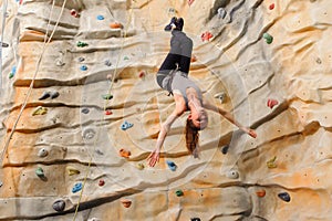 Woman climbing on man-made cliff