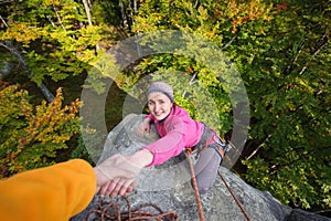 Woman climbing in the nature on large boulder