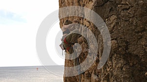 A woman is climbing a rock wall with a backpack