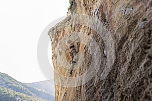 A woman is climbing a rock wall