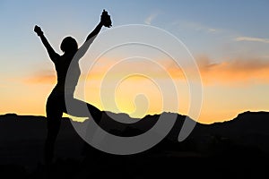 Woman climbing success silhouette in mountains sunset